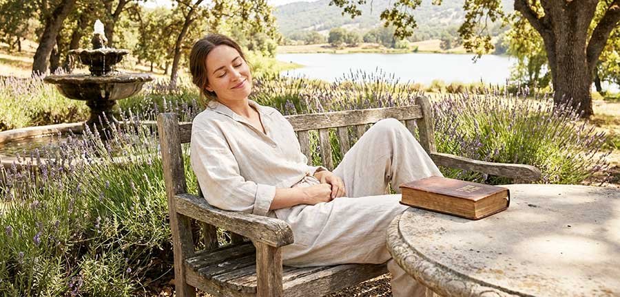 Uma mulher descansando com a biblia ao lado